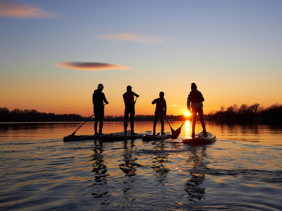 夕陽に向かってSUPを楽しむ人