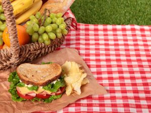 野菜たっぷりのサンドイッチと果物いっぱいのバスケット