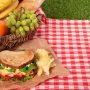 野菜たっぷりのサンドイッチと果物いっぱいのバスケット